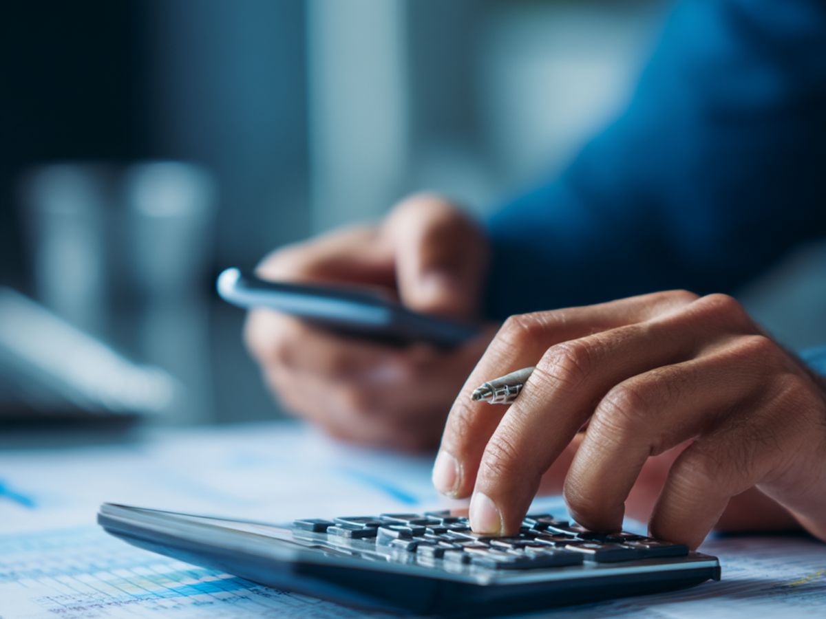 Mains utilisant une calculatrice sur des documents comptables