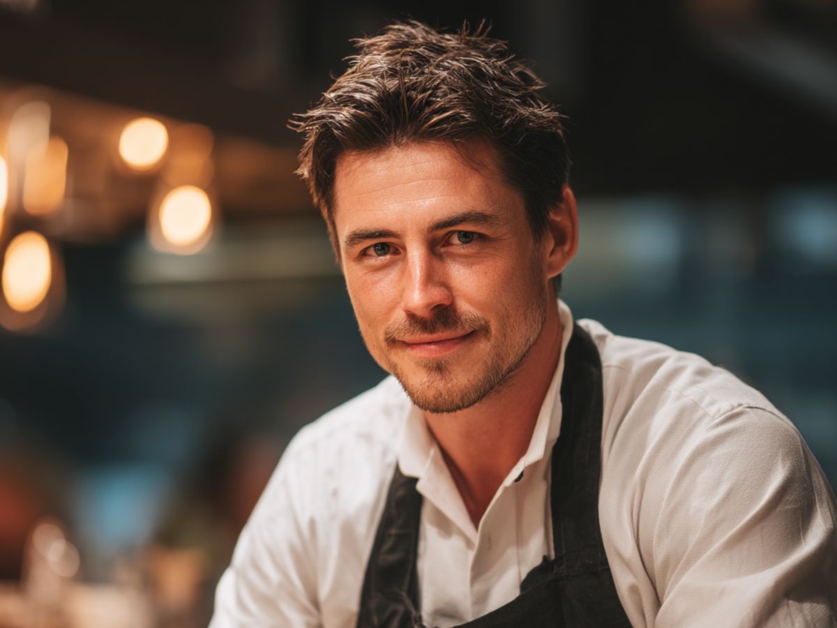 Employé de restauration souriant, en tablier